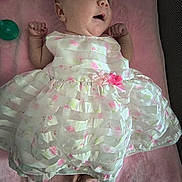 Ashlee joined the competition — help win amazing prizes! baby, infant, dress, white_dress, pink_flowers, blanket, pacifier, bottle, lying_down, cute, small_hands, small_feet, soft_texture, indoors, child, newborn, portrait, expression, resting, clothing