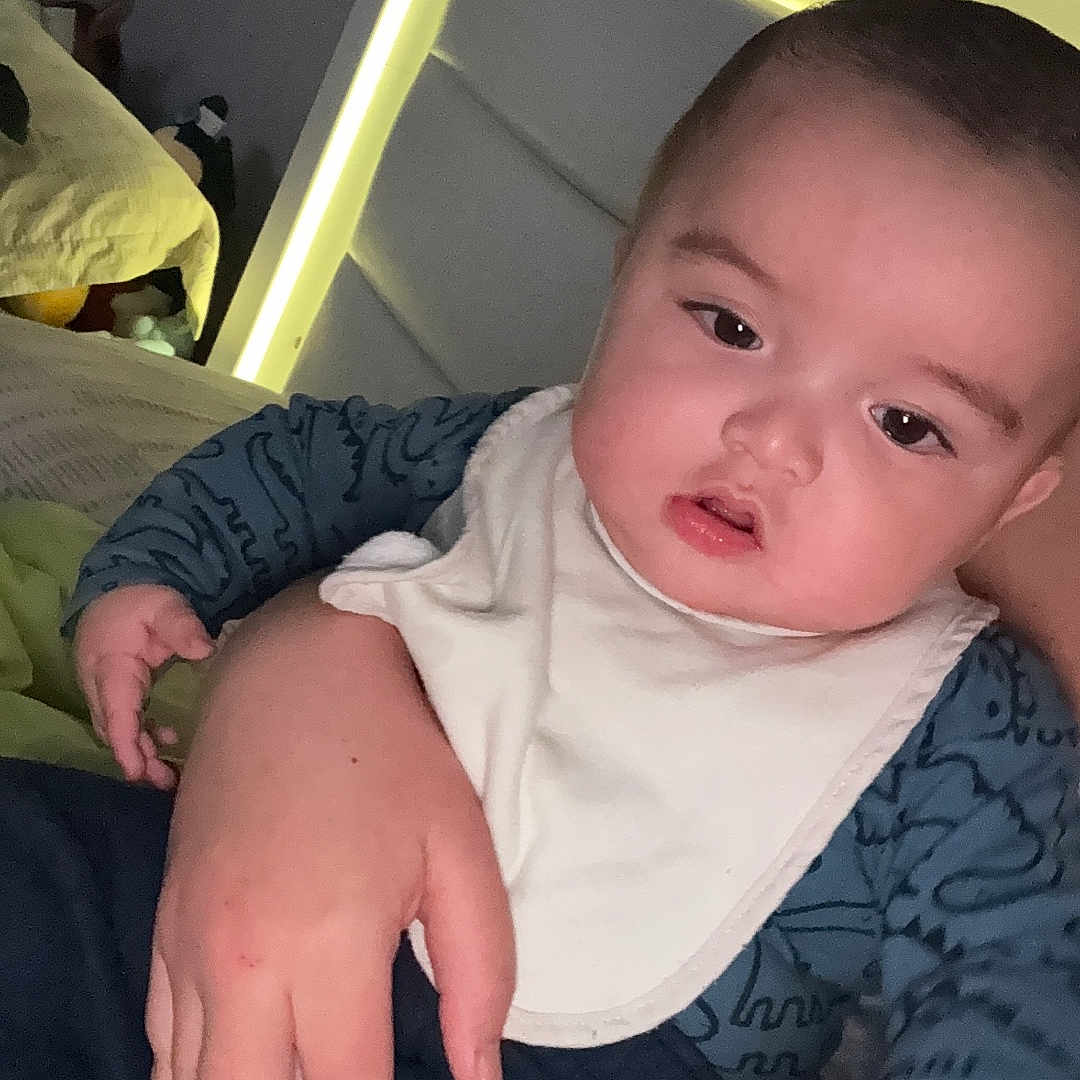 Keylen Zapata is registered to the contest to win money with this photo: baby, bed, bib, blanket, brushing, caretaker, child, clothing, comfort, expression, face, furniture, hand, headboard, indoor, lighting, person, skin, sleeve, young