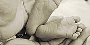 Nelly a rejoint le concours — aidez-le/la à gagner de superbes lots ! baby_feet, adult_hands, black_and_white, close_up, tender, newborn, foot, hand, skin, protection, care, small, soft, blurred_background, family, love, parent, infant, touch, comfort