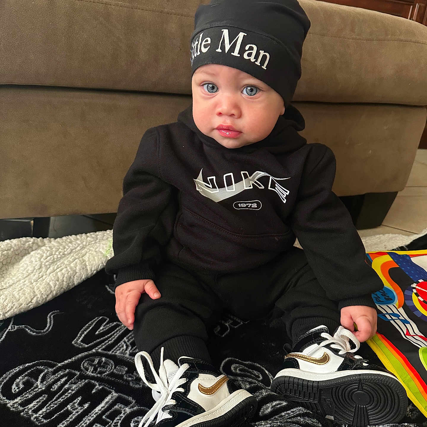 Deon Matthews is registered to the contest to win money with this photo: baby, bodypart, cap, clothing, couch, face, finger, footwear, furniture, hand, hat, head, pants, person, photography, portrait, runningshoe, shoe, sitting, sneaker