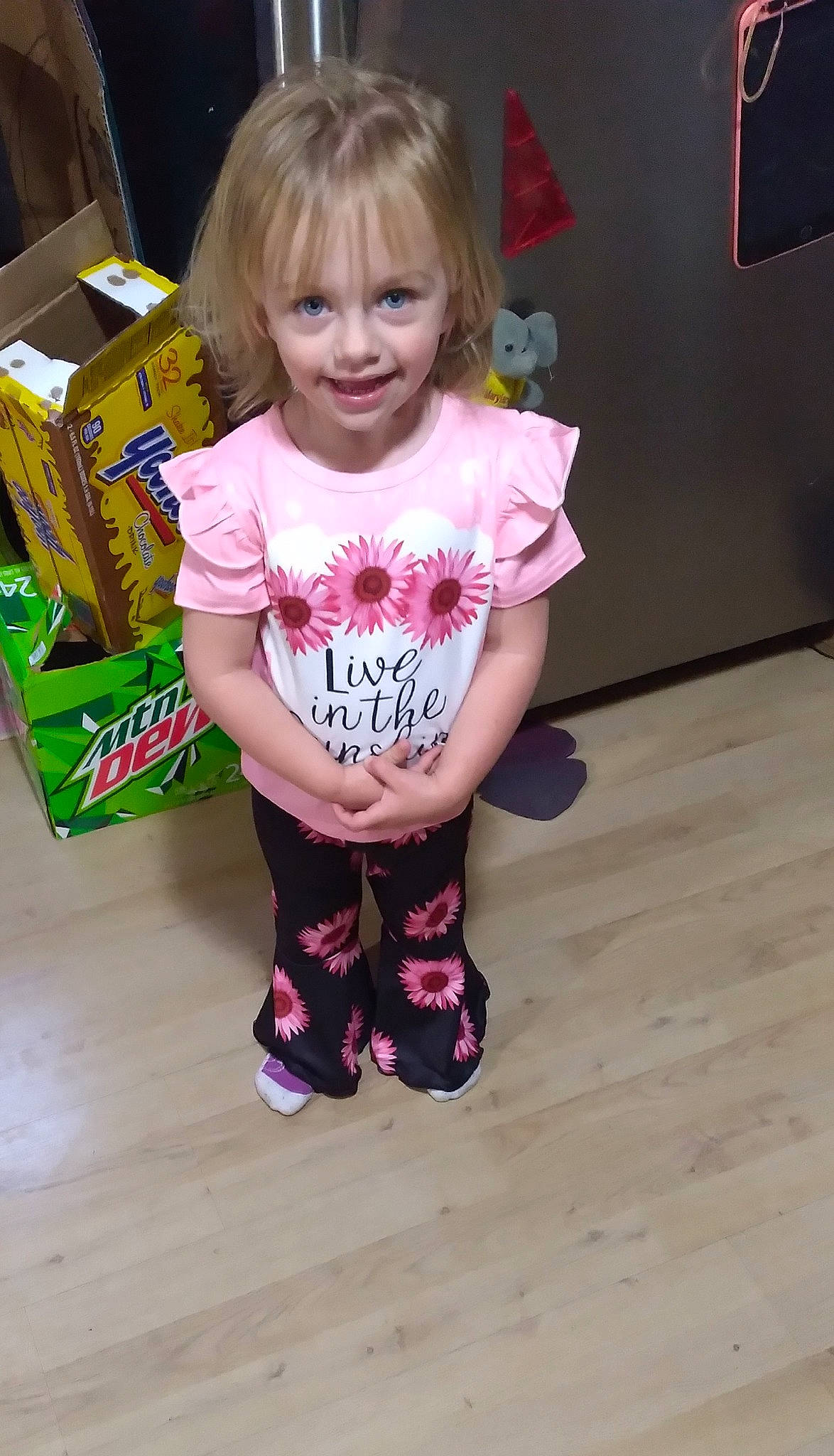 Adilynn is registered to the contest to win money with this photo: active_pants, baby_toddler_clothing, box, cheek, child, flooring, fun, hair, hardwood, head, human_leg, joy, magenta, pattern, person, pink, sleeve, smile, sock, t_shirt