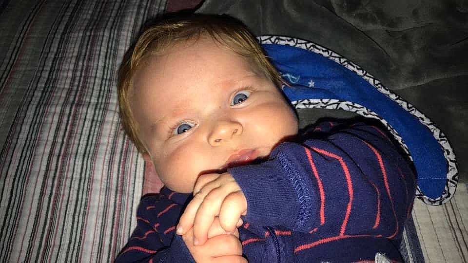 Bentley is registered to the contest to win money with this photo: arm, baby, blue, cheek, child, chin, ear, eye, face, finger, hand, head, iris, lip, mouth, nose, organ, person, skin, smile