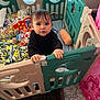 toddler, child, playpen, toy, blanket, pigtails, indoor, person, cute, curious, furniture, colorful, soft_toy, carpet, hand, expression, baby, clothing, home, gate