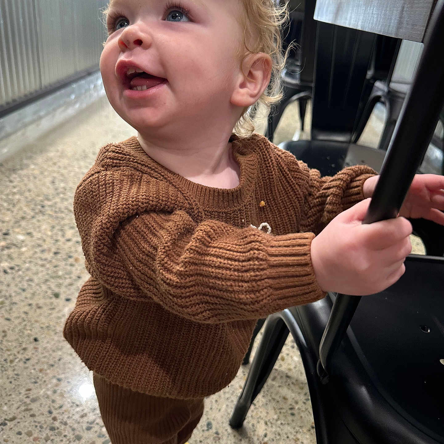 Koko is registered to the contest to win money with this photo: baby, bodypart, chair, city, clothing, coat, face, finger, furniture, hand, happy, head, jacket, knitwear, pants, person, photography, portrait, smile, sweater