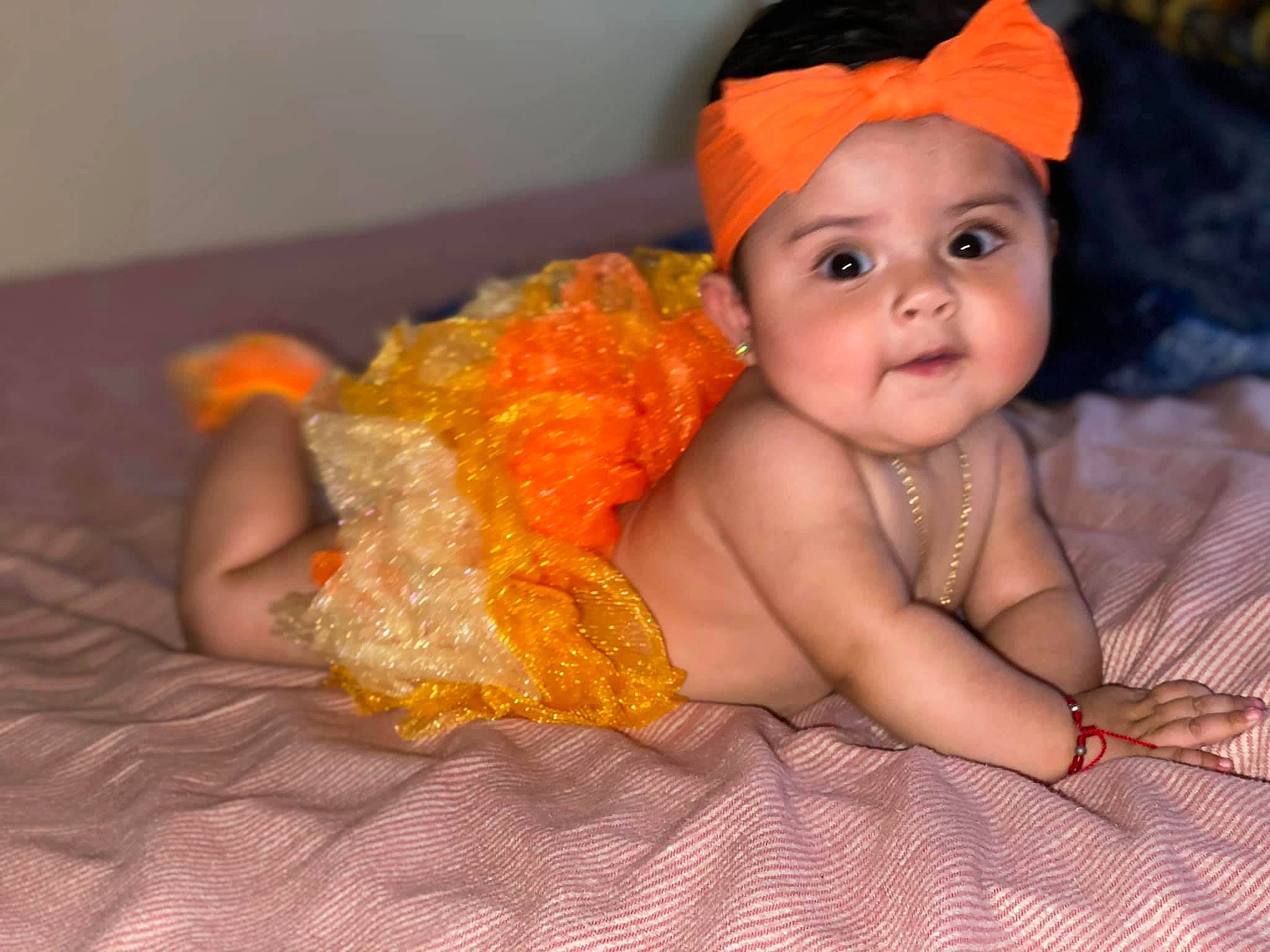 Daniela is registered to the contest to win money with this photo: baby, child, costume, hair_accessory, headgear, headpiece, headwear, orange, person, smile, toddler, yellow