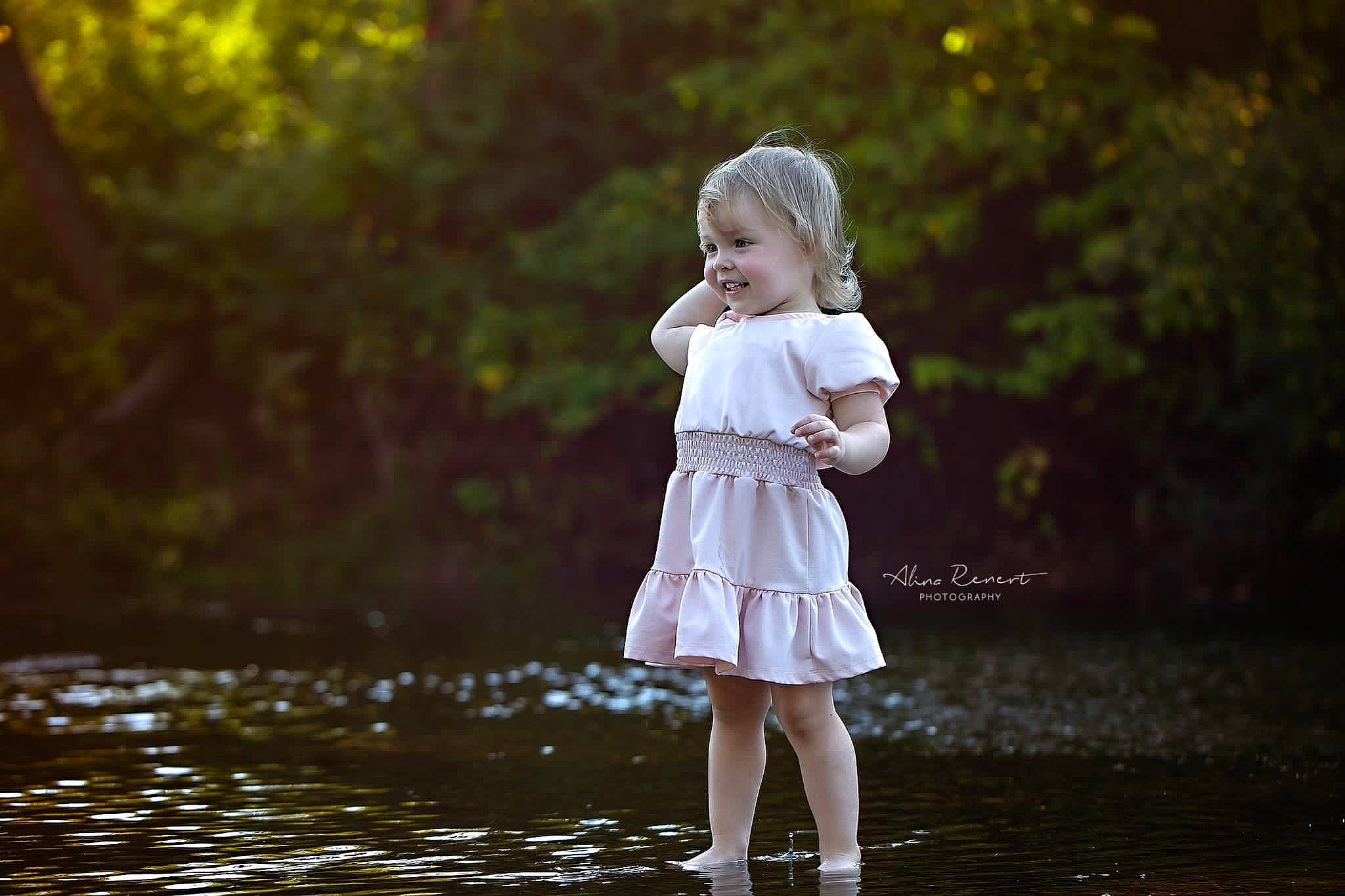 Maya joined the competition — help win amazing prizes! bank, bridal_clothing, bridal_party_dress, child, day_dress, dress, flash_photography, gesture, grass, happy, human_body, joy, lake, people_in_nature, person, plant, smile, sunlight, toddler, tree