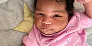 Stori is registered to the contest to win money with this photo: baby, blanket, child, closeup, curly_hair, cute, expression, fabric, face, hand, indoor, infant, lying_down, pattern, pink_clothing, portrait, sleeping_area, soft_toys, star_pillow, young