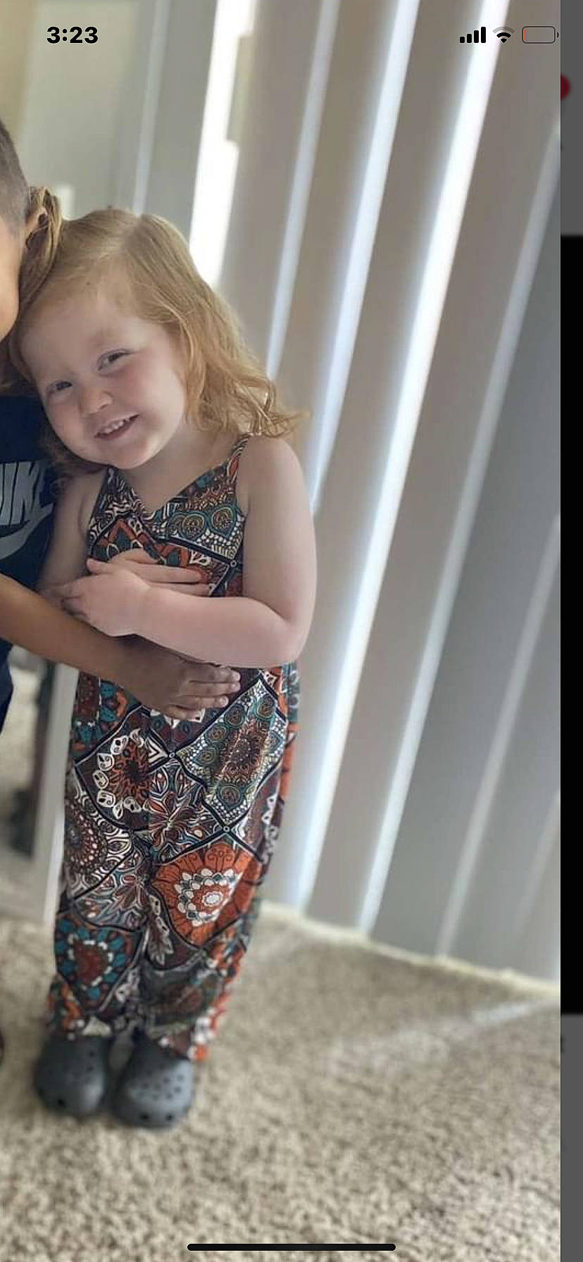 Serenity is registered to the contest to win money with this photo: arm, baby, brown_hair, child, curtain, face, fashion_design, hair, happy, human_leg, joy, long_hair, pattern, person, plaid, sleeve, smile, t_shirt, toddler, trunk