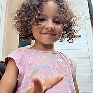 Leya a rejoint le concours — aidez-le/la à gagner de superbes lots ! child, curly_hair, smile, pink_shirt, outdoor, door, hand, sea_creatures, starfish, seahorse, playful, young, person, casual_clothing, expression, portrait, front_view, daylight, happy, skin