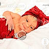 baby, bow, child, cute, eyes, face, hand, headband, indoors, infant, lying_down, newborn, portrait, red_clothing, resting, skin, smile, soft, watermark, white_blanket