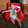 baby, birthday, car_theme, carpet, child, clothing, cute, diapers, furniture, happy, indoor, lightning_mcqueen, onesie, person, portrait, red_chair, smiling, toddler, toy_chair, wooden_cabinet