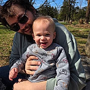 Kingsley joined the competition — help win amazing prizes! toddler, man, child, outdoor, park, sunlight, smile, sunglasses, beard, sweater, bear_pattern, tree, grass, casual_clothing, happy, holding, nature, person, daylight, family