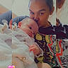 baby, infant, child, young_person, face, kissing, affection, portrait, indoor, blanket, wrapped, sitting, holding, family, tender, heart_sticker, colorful_clothing, close_up, photograph, cozy