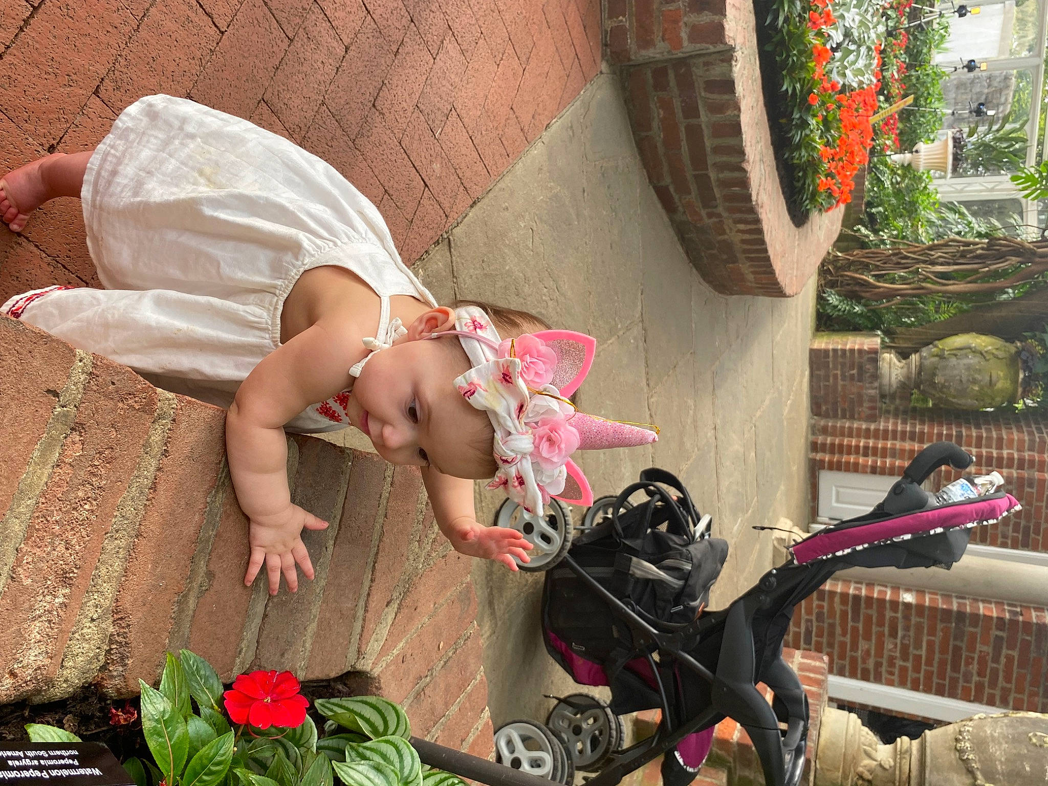Phoenix is registered to the contest to win money with this photo: baby, barefoot, fawn, flower, fun, grass, hat, human_leg, leaf, leg, leisure, person, petal, pink, plant, rose, sandal, sun_hat, thigh, toddler