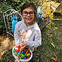 Celena a rejoint le concours — aidez-le/la à gagner de superbes lots ! child, girl, glasses, smiling, basket, candy, outdoor, garden, plants, greenery, watering_can, flowers, leaves, sunlight, casual_clothing, sneakers, happy, nature, playful, spring