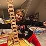 Celena participe au concours pour gagner de l'argent avec cette photo : child, girl, smile, wooden_blocks, tower, table, indoor, toy, playroom, red_pants, black_sweater, happy, construction, wood, floor, home, furniture, arm_outstretched, face, person