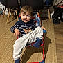 Jonas a rejoint le concours — aidez-le/la à gagner de superbes lots ! bag, black_chairs, carpet, casual, chair, child, cute, home, indoor, person, relaxed, smiling, socks, striped_shirt, stroller, table, toddler, toy, wooden_floor, young_child