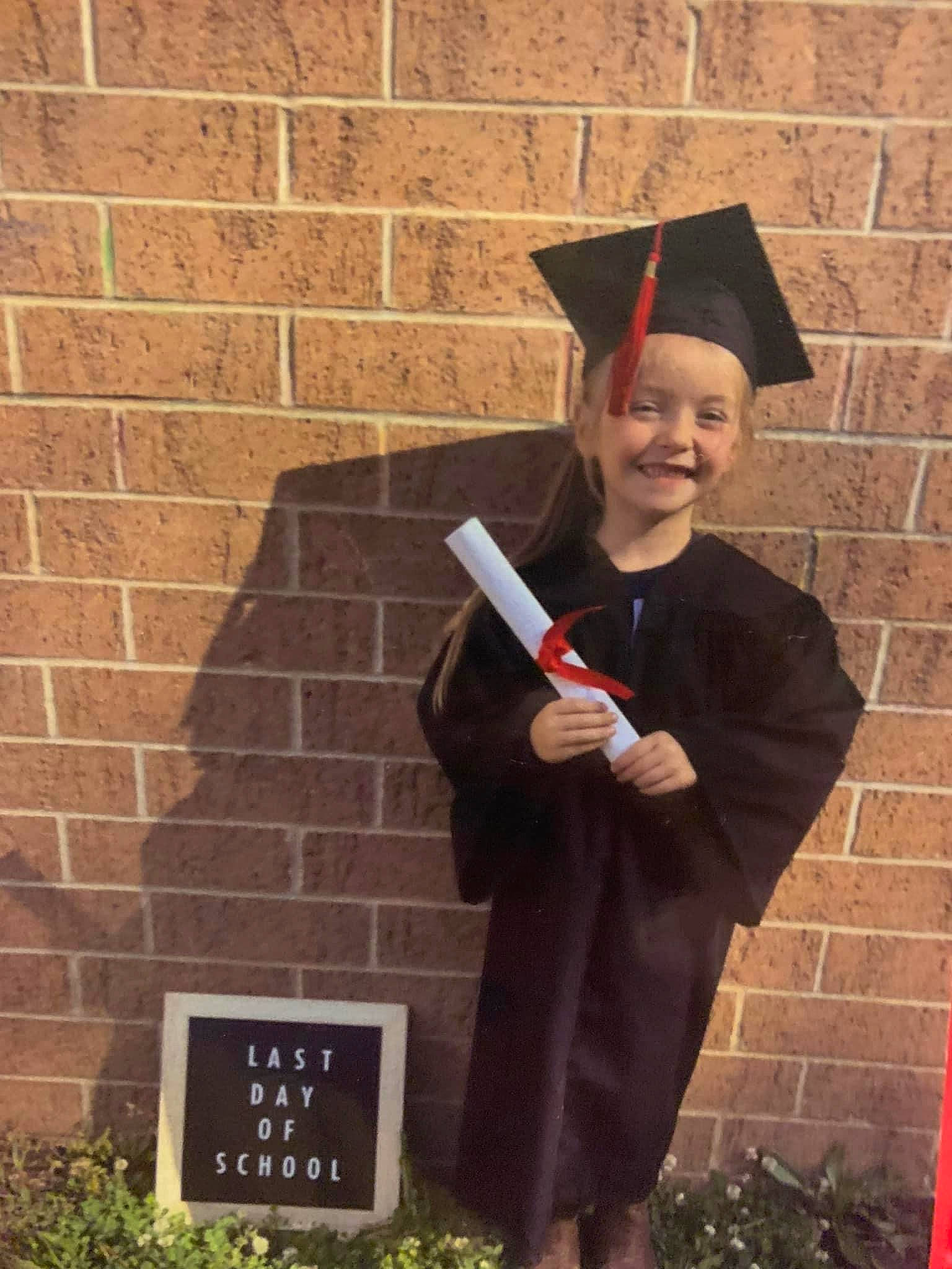 Annabelle joined the competition — help win amazing prizes! academic_dress, academic_institution, brick, brickwork, costume, event, formal_wear, fun, gesture, graduation, grass, happy, headgear, headwear, joy, mortarboard, person, phd, plant, public_event