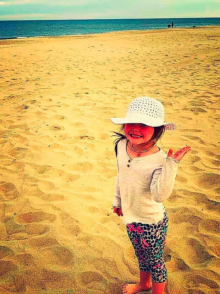 Annabelle is registered to the contest to win money with this photo: beach, blue, body_of_water, fun, happy, hat, headgear, headwear, joy, landscape, light, natural_environment, people_in_nature, people_on_beach, person, sky, sleeve, summer, sun_hat, sunlight