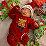 baby, infant, christmas, holiday, red_clothing, santa_hat, sleeping, gift_wrap, presents, plush, reindeer, cozy, blanket, festive, cute, child, holiday_season, smiling_toy, soft_texture, indoors
