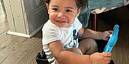 Morgan Xavier joined the competition — help win amazing prizes! toddler, child, curly_hair, smiling, toy, tablet, crate, sitting, indoor, floor, blanket, chair, wooden_floor, white_shirt, mickey_mouse, cute, happy, person, playful, home