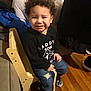 Morgan Xavier joined the competition — help win amazing prizes! toddler, child, smiling, curly_hair, black_shirt, ripped_jeans, wooden_chair, indoor, couch, wooden_floor, happy, sitting, person, casual_clothing, footwear, small_chair, cute, portrait, young_child, cozy