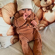 Timéo Djoudi participe au concours pour gagner de l'argent avec cette photo : baby, infant, child, onesie, hat, bear, stuffed_animal, pillow, couch, blanket, cute, cozy, indoors, soft_toys, sitting, finger_in_mouth, expression, comfortable, warm_clothing, portrait