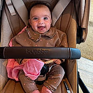 Nala is registered to the contest to win money with this photo: baby, child, smiling, stroller, bugaboo, clothing, pink, brown, socks, beads, bracelet, fabric, happy, indoor, seat, person, cute, portrait, infant, toy