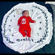 Malik-Abdi joined the competition — help win amazing prizes! baby, infant, sleeping, red_clothing, onesie, blanket, circular_blanket, milestone, months, numbers, wooden_ring, face, peaceful, lying_down, bedroom, soft_texture, decorative, football_club, liverpool, cute