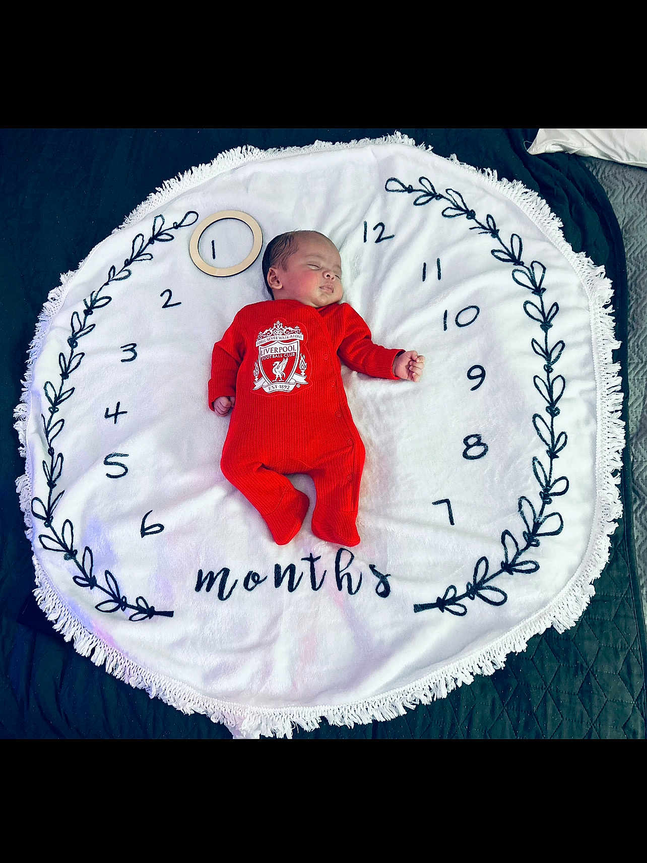 Malik-Abdi joined the competition — help win amazing prizes! baby, infant, sleeping, red_clothing, onesie, blanket, circular_blanket, milestone, months, numbers, wooden_ring, face, peaceful, lying_down, bedroom, soft_texture, decorative, football_club, liverpool, cute