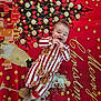 baby, child, pajamas, gingerbread, christmas, holiday, blanket, smile, happy, face, festive, tree, decorations, stars, champagne, glasses, red, white, pattern, lying_down