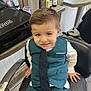 barber_chair, boy, child, clothing, floor, furniture, hair_products, hair_spray, haircut, indoor, mirror, person, portrait, salon, seat, shoes, short_hair, smiling, tie, vest