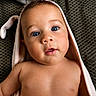 baby, child, blue_eyes, towel, hair, cute, skin, portrait, close_up, infant, face, curious, soft_texture, indoors, expression, naked_torso, lying_down, head, young, person