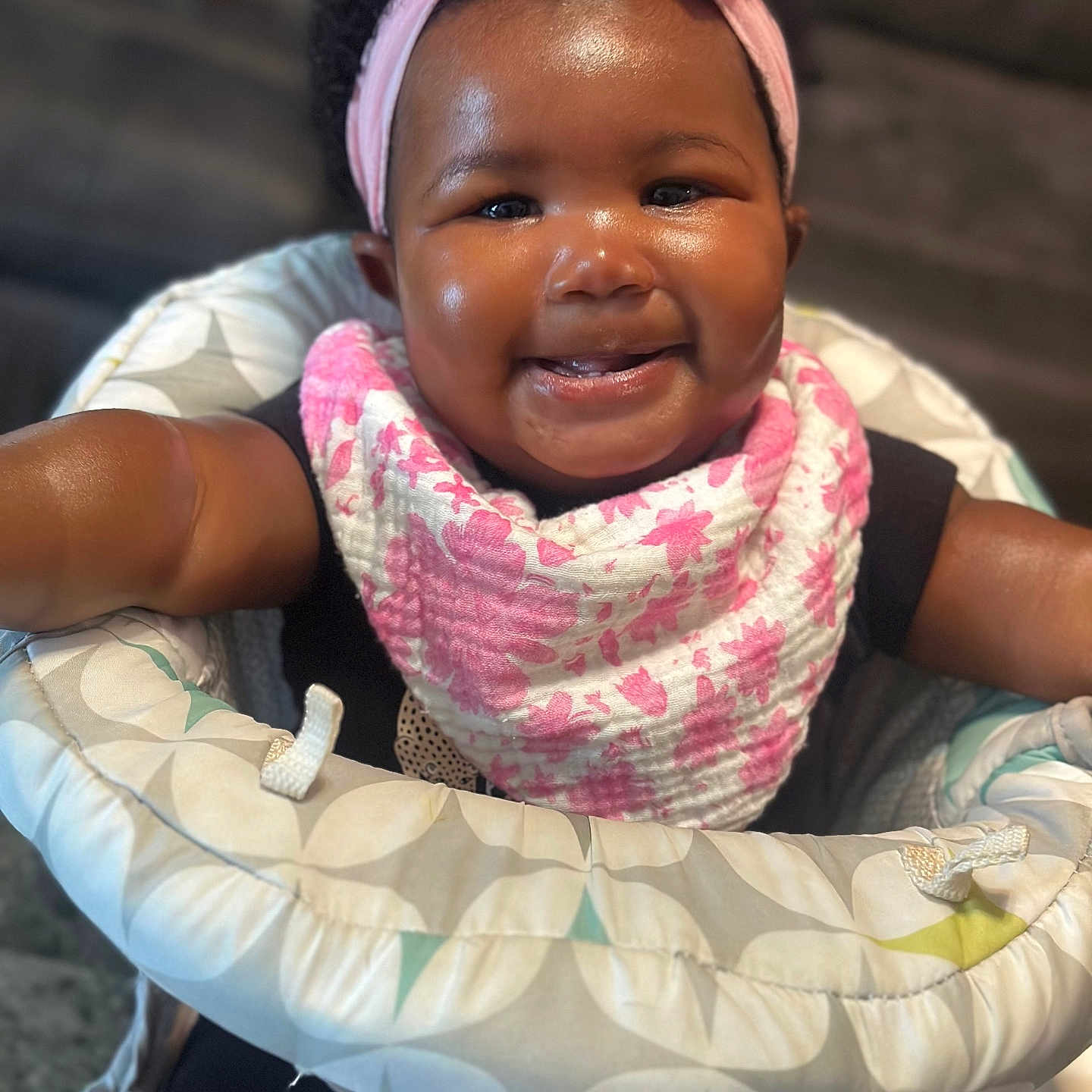 Sunniyah joined the competition — help win amazing prizes! adorable, apparel, baby, baby_girl, bib, black_clothing, child, closeup, cushion, cute, floral, happy, headband, indoor, infant, person, pink, portrait, seat, smiling