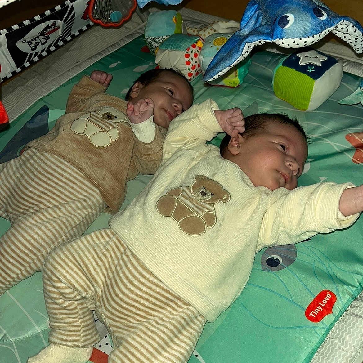 Aslan Et Sinan participe au concours pour gagner de l'argent avec cette photo : baby, child, colorful, cute, floor_mat, indoor, infant, lying_down, matching_outfits, newborn, person, play_area, play_mat, plush_toy, sleepwear, soft_toys, striped_clothing, teddy_bear, toddler, toy