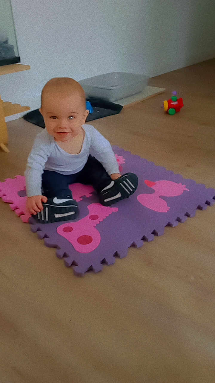 Tyméo a rejoint le concours — aidez-le/la à gagner de superbes lots ! baby, child, indoor, playmat, toy, sneakers, floor, smile, person, head, clothing, pants, footwear, expression, room, plastic_toy, curious, seated, young, light