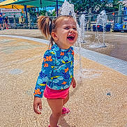 Everly is registered to the contest to win money with this photo: architecture, child, clothing, face, female, fountain, girl, grass, happy, head, nature, outdoors, park, person, photography, plant, portrait, shorts, summer, water