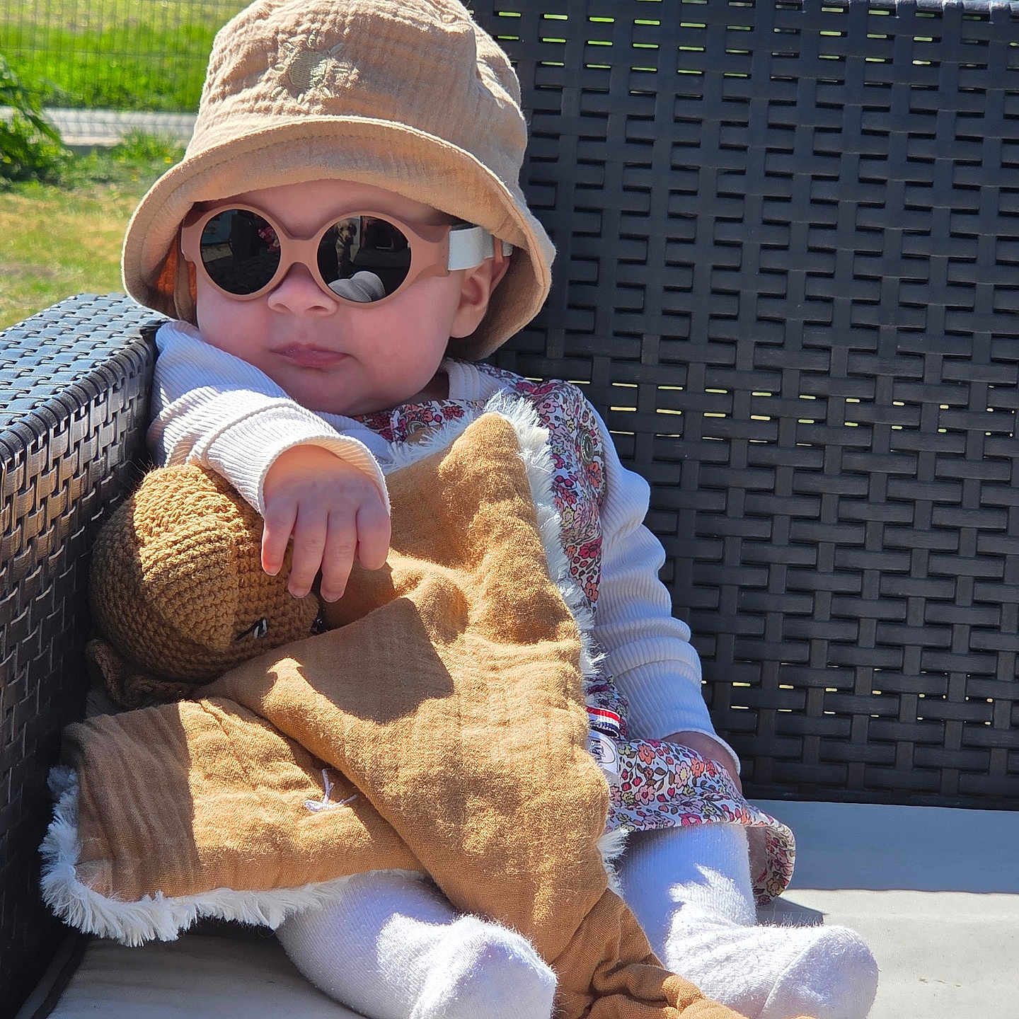 Lou participe au concours pour gagner de l'argent avec cette photo : baby, blanket, candid, child, cute, fashion, hat, infant, nature, outdoor, plush_toy, portrait, relaxing, shaded_face, sock, summer, sunglasses, sunlight, white_clothing, woven_chair