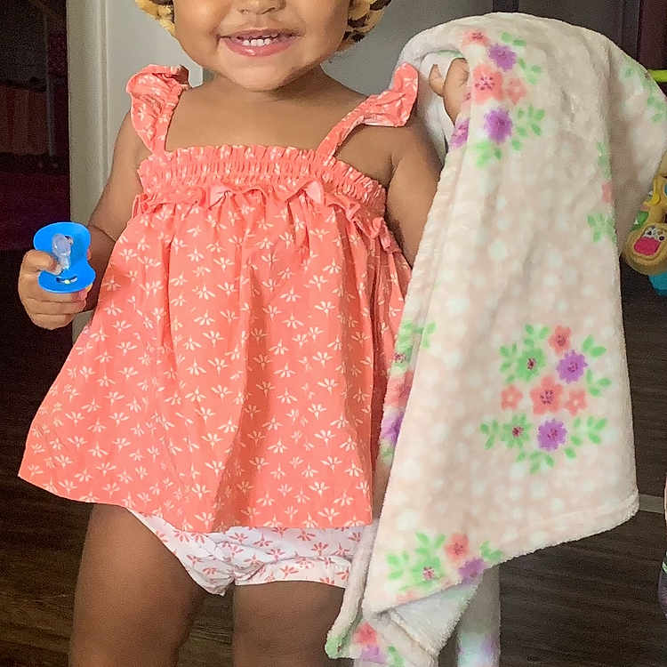 Essence is registered to the contest to win money with this photo: bonnet, cap, child, clothing, costume, dress, face, female, footwear, furniture, girl, hat, head, indoors, person, photography, portrait, sandal, shoe, wood