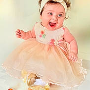 Mila joined the competition — help win amazing prizes! baby, child, dress, headband, flower, smile, happy, curly_hair, sitting, shoes, white_socks, fruit, peach_color, pink_ribbon, cute, indoor, portrait, infant, celebration, joy