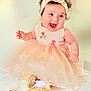baby, child, dress, headband, flower, smile, happy, curly_hair, sitting, shoes, white_socks, fruit, peach_color, pink_ribbon, cute, indoor, portrait, infant, celebration, joy