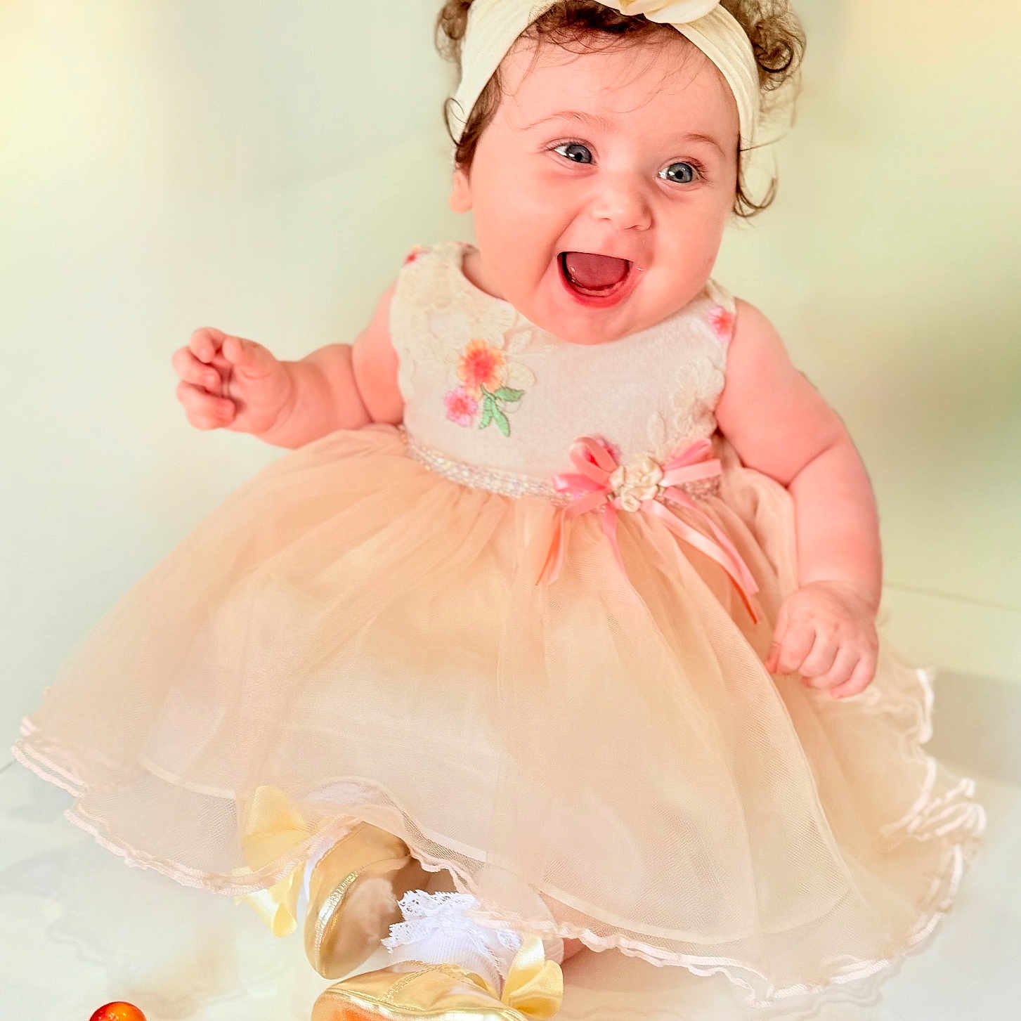 Mila joined the competition — help win amazing prizes! baby, celebration, child, curly_hair, cute, dress, flower, fruit, happy, headband, indoor, infant, joy, peach_color, pink_ribbon, portrait, shoes, sitting, smile, white_socks