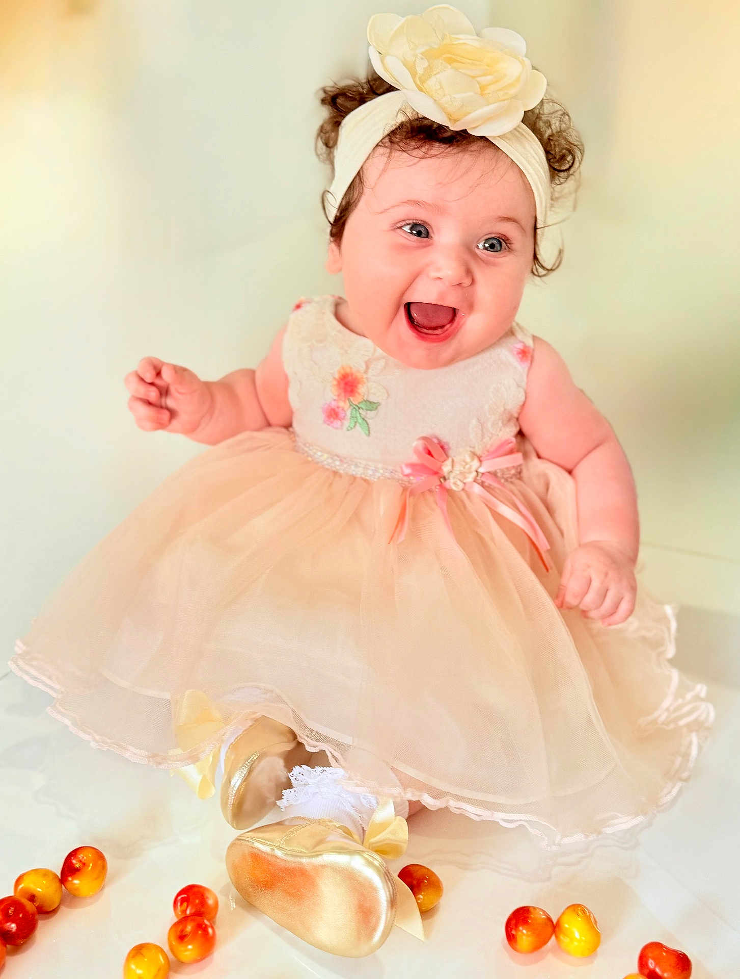Mila joined the competition — help win amazing prizes! baby, child, dress, headband, flower, smile, happy, curly_hair, sitting, shoes, white_socks, fruit, peach_color, pink_ribbon, cute, indoor, portrait, infant, celebration, joy