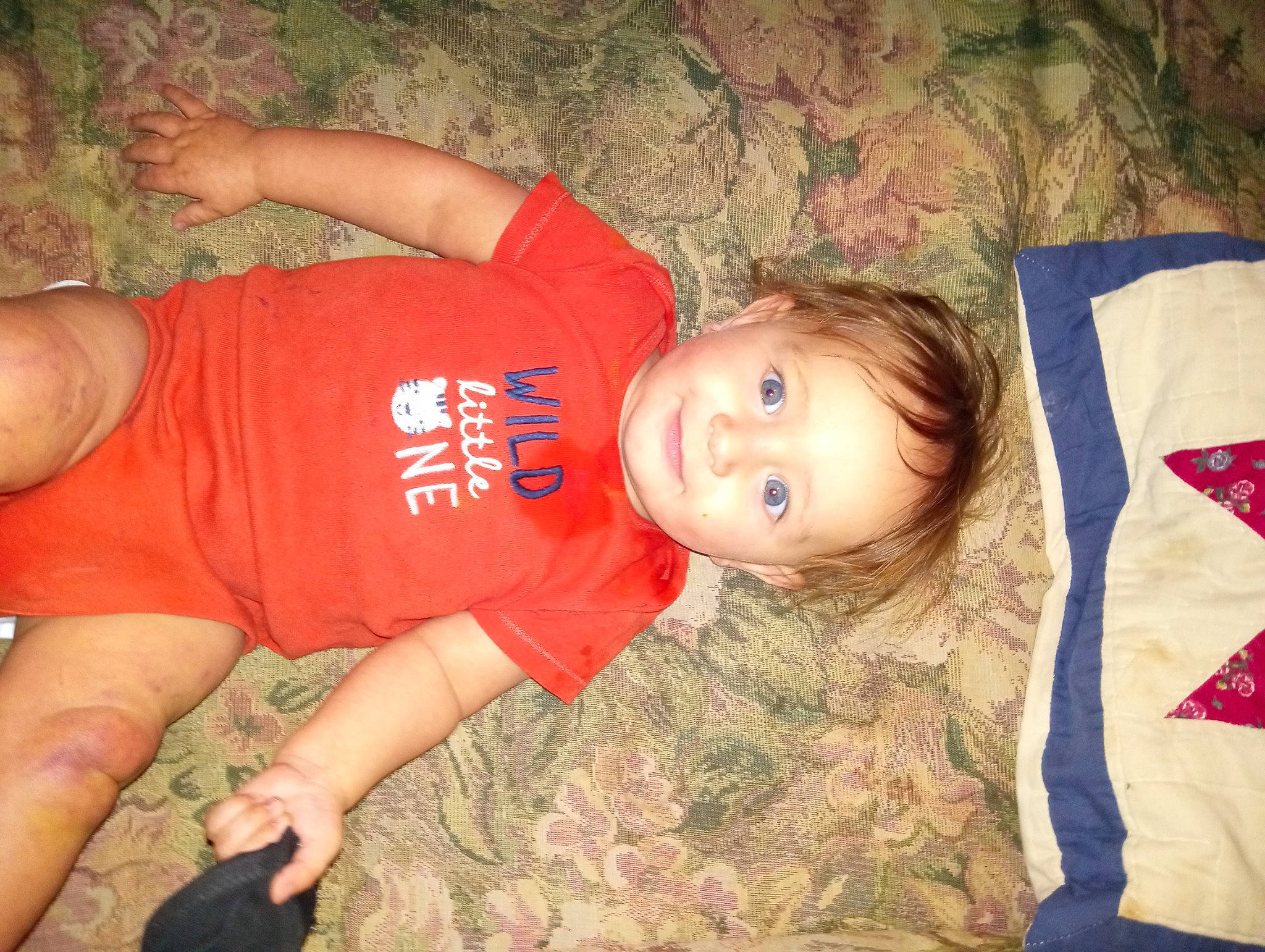 Chevy is registered to the contest to win money with this photo: baby_toddler_clothing, child, elbow, eye, flooring, foot, fun, hair, happy, human_leg, knee, pattern, person, sitting, skin, sleeve, smile, thigh, thumb, toddler