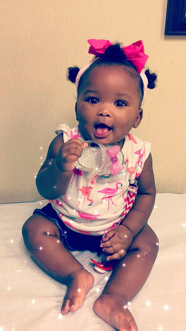 Aubri is registered to the contest to win money with this photo: baby, cheek, child, ear, eye, face, forehead, fun, hair_accessory, head, headband, headgear, lip, mouth, nose, person, pink, sitting, skin, smile