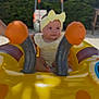baby, yellow_headband, bow, inflatable_float, yellow, outdoor, greenery, child, cute, smile, play, summer, sunlight, person, infant, fun, water_toy, seat, happy, portrait