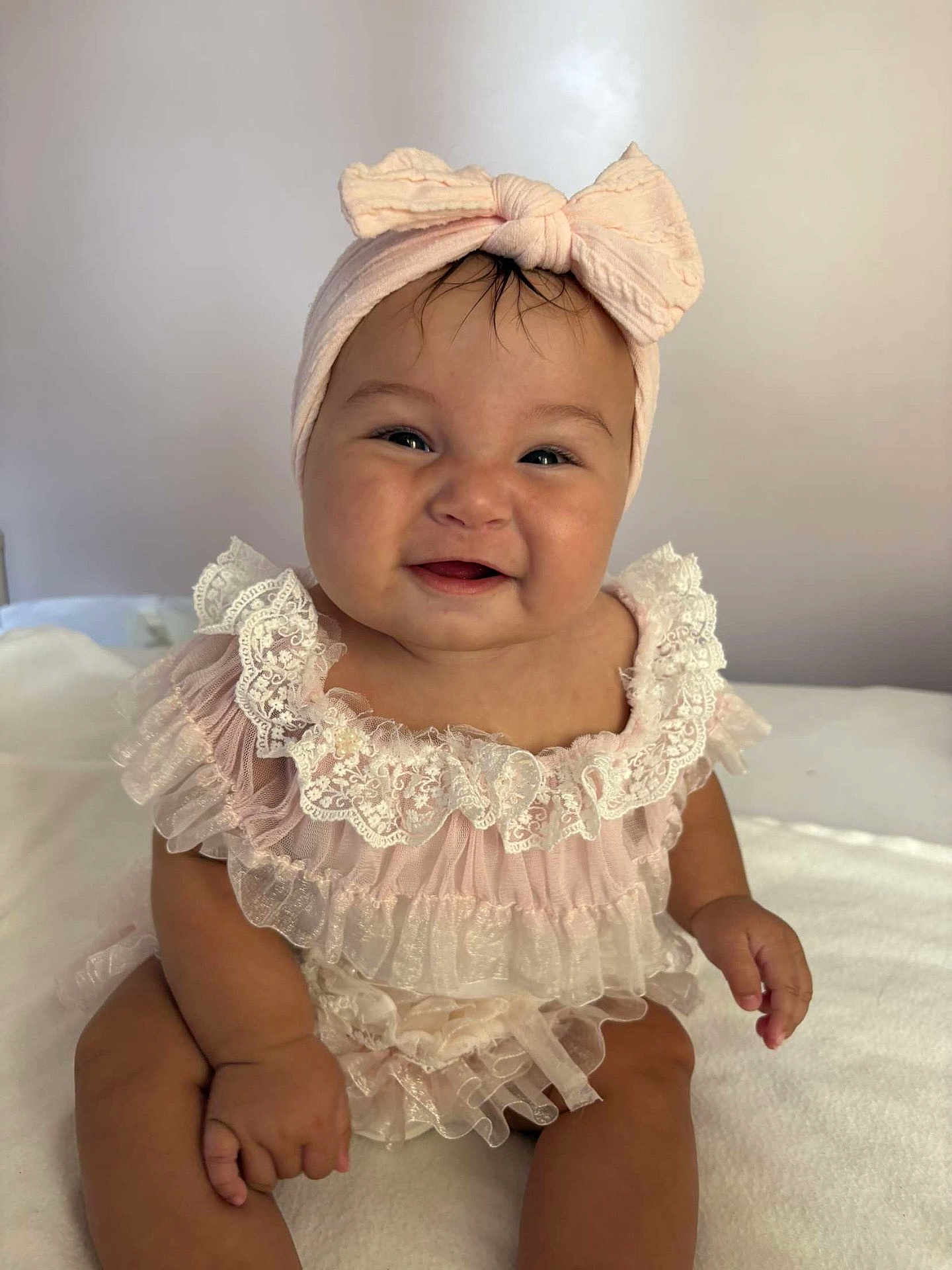 Ruby participe au concours pour gagner de l'argent avec cette photo : baby, child, smile, headband, bow, pink, dress, frills, lace, sitting, happy, cute, infant, soft, white_background, portrait, indoors, person, adorable, chubby