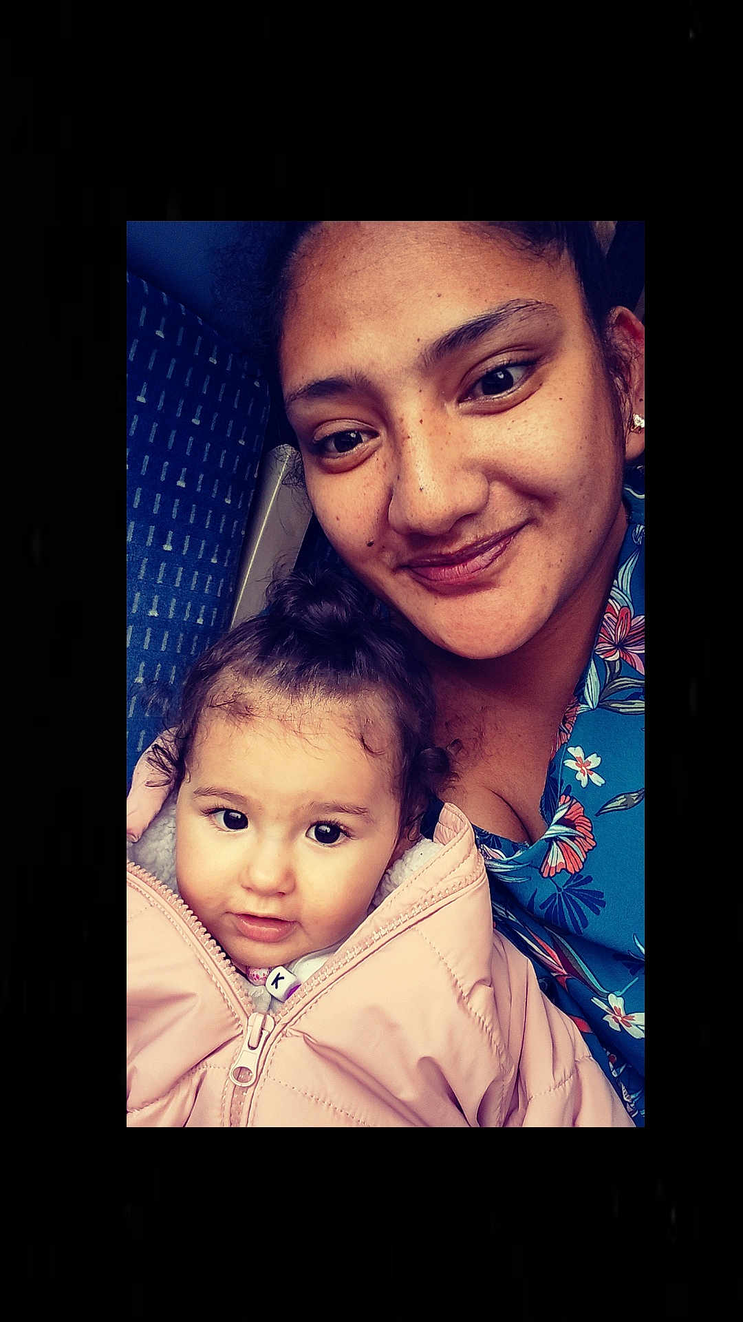 Kuanui a rejoint le concours — aidez-le/la à gagner de superbes lots ! woman, toddler, child, face, smile, jacket, pink, blue, pattern, seat, indoor, portrait, closeup, person, hair, eyebrows, eyes, skin, happy, warm