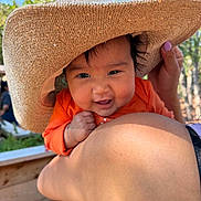 Arabella joined the competition — help win amazing prizes! adult, baby, blue_sky, child, closeup, daylight, eyes, face, family, happy, holding, infant, mouth, nature, orange_clothing, outdoor, portrait, smiling, sun_hat, trees