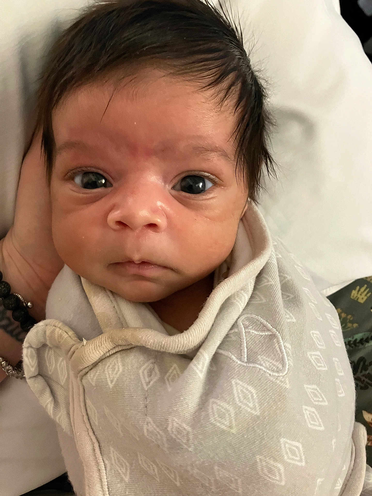 Lorenzo is registered to the contest to win money with this photo: baby, infant, swaddle, wrapped, face, eyes, hand, clothing, newborn, portrait, expression, cute, person, skin, hair, indoors, closeup, soft, fabric, resting